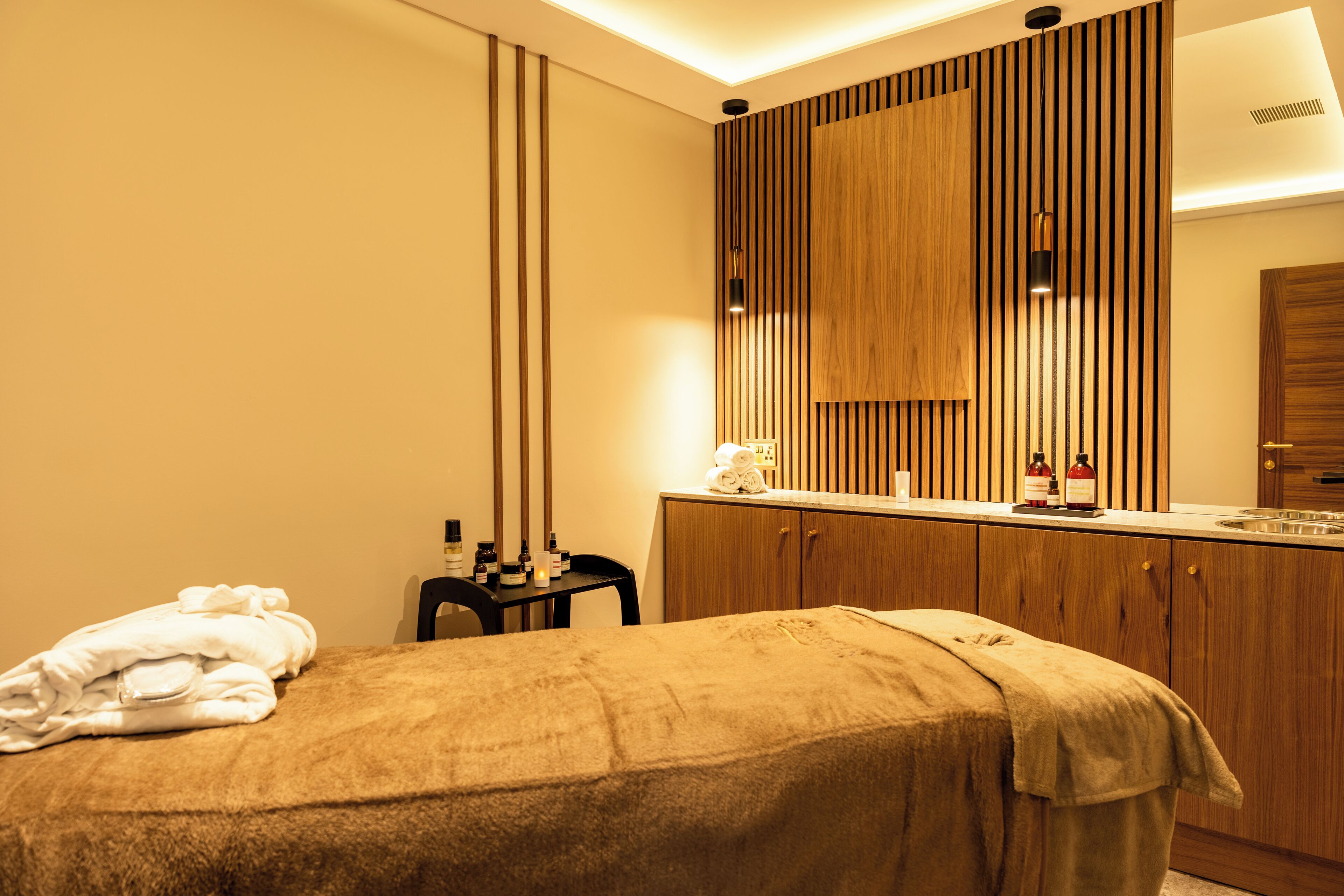 Uma casa de banho moderna com toucador de madeira, uma pia e uma toalha na cama.