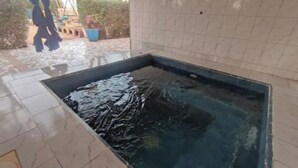 Un bain à remous rectangulaire, dont l’intérieur et le sol environnant sont recouverts de carreaux.