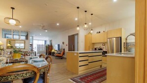 Una cocina moderna con armarios de madera, una isla central e iluminación colgante.