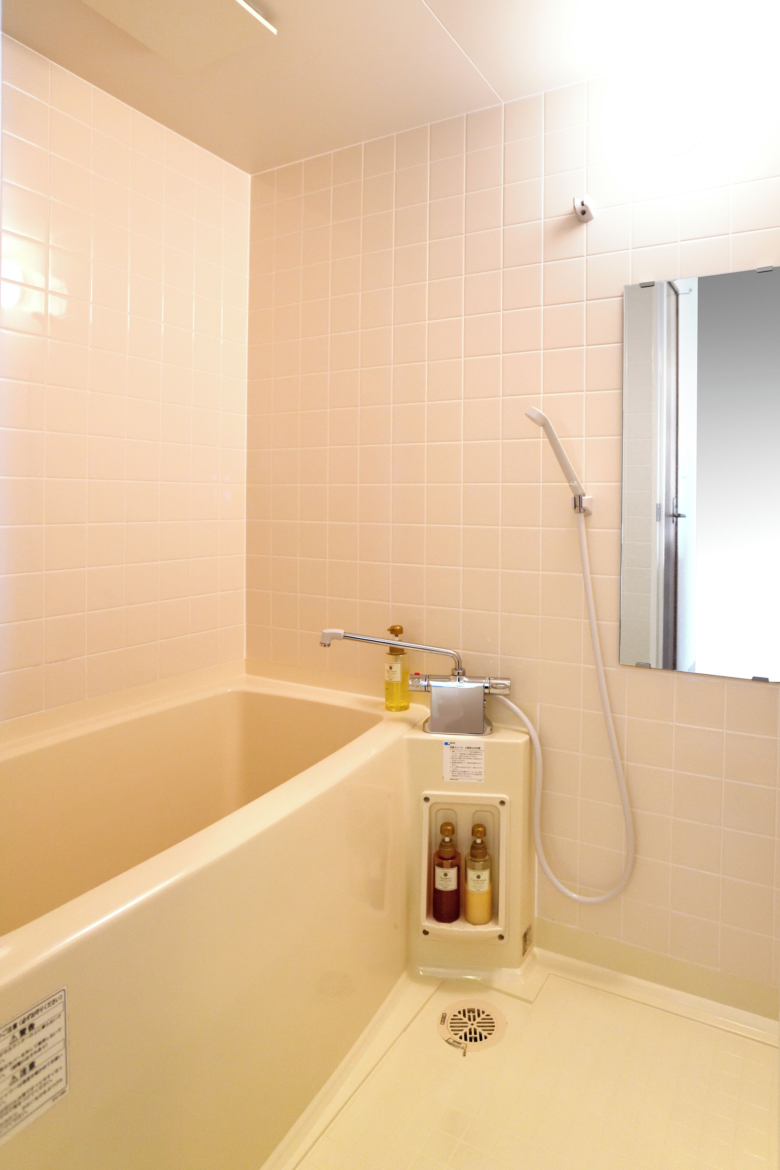 Un baño con bañera, ducha y espejo.