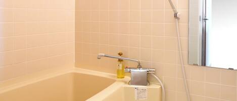Un baño con bañera, ducha y espejo.