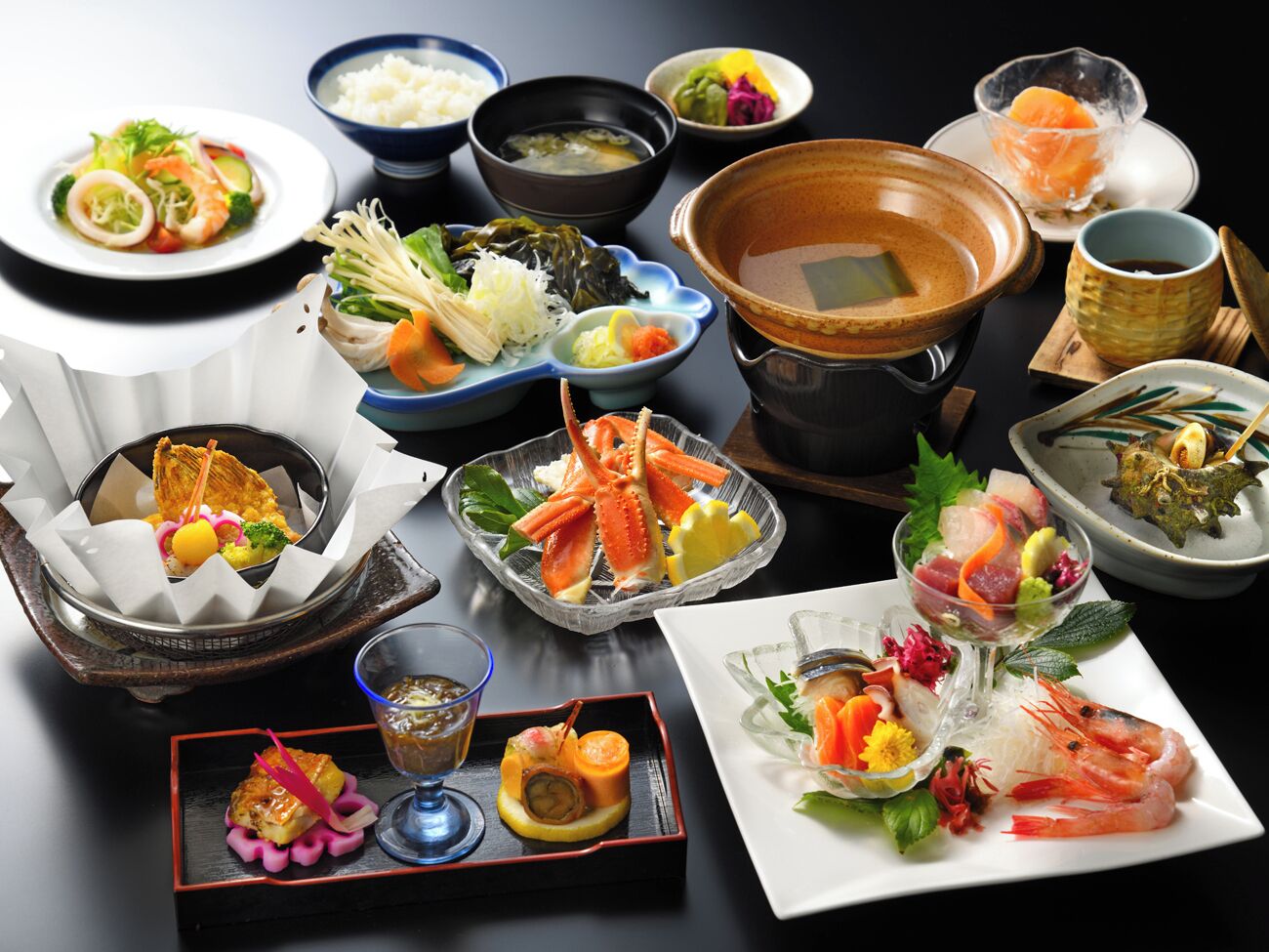 A variety of dishes including seafood, vegetables, and rice, presented on a table with multiple bowls and plates.