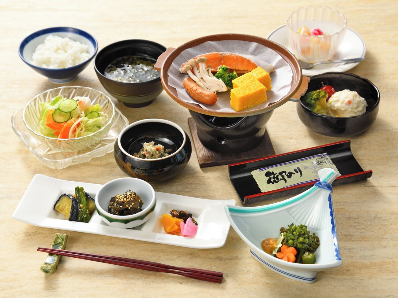 Variedad de platos japoneses, incluyendo sushi, sashimi y tempura, dispuestos sobre una mesa de madera.