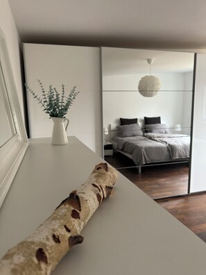 Een moderne slaapkamer met een bed, nachtkastje en een potplant.