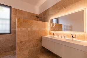 Een douche, handdoeken, zeep, toiletpapier