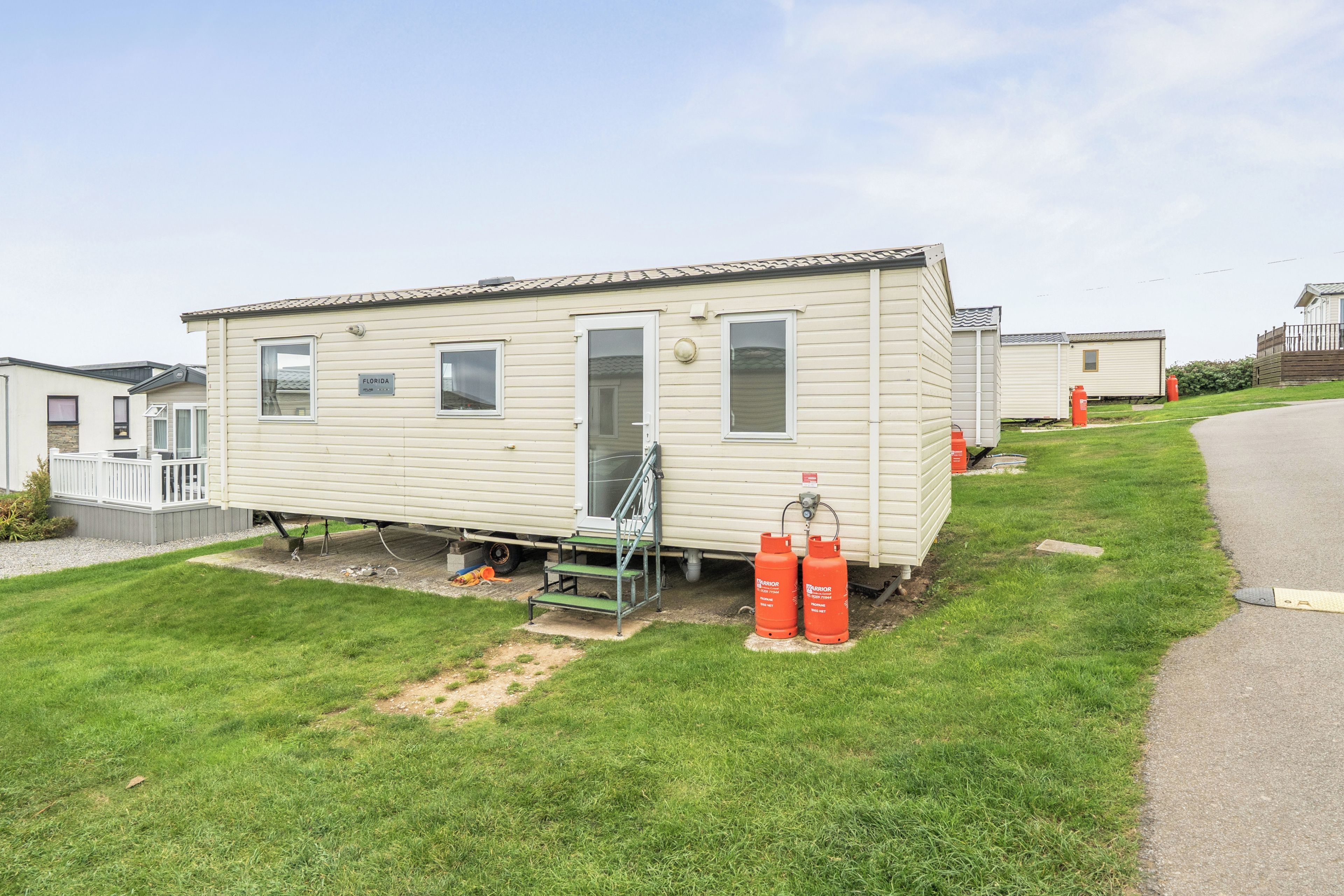 A single-story mobile home with a front porch and a small attached garage.