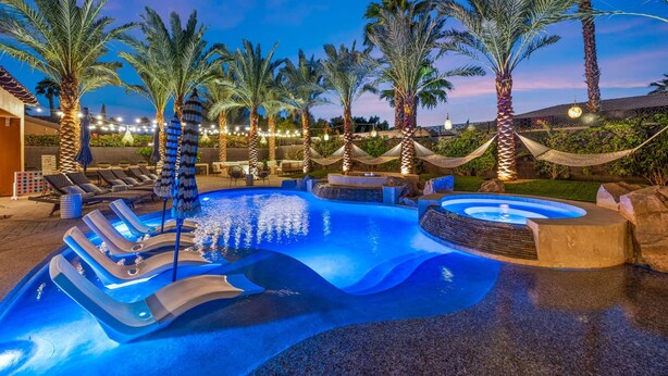 A pool area with lounge chairs and palm trees. - Luxe Villa Tulum in Indio (Indio)