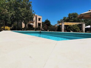 A swimming pool with a stone building in the background.