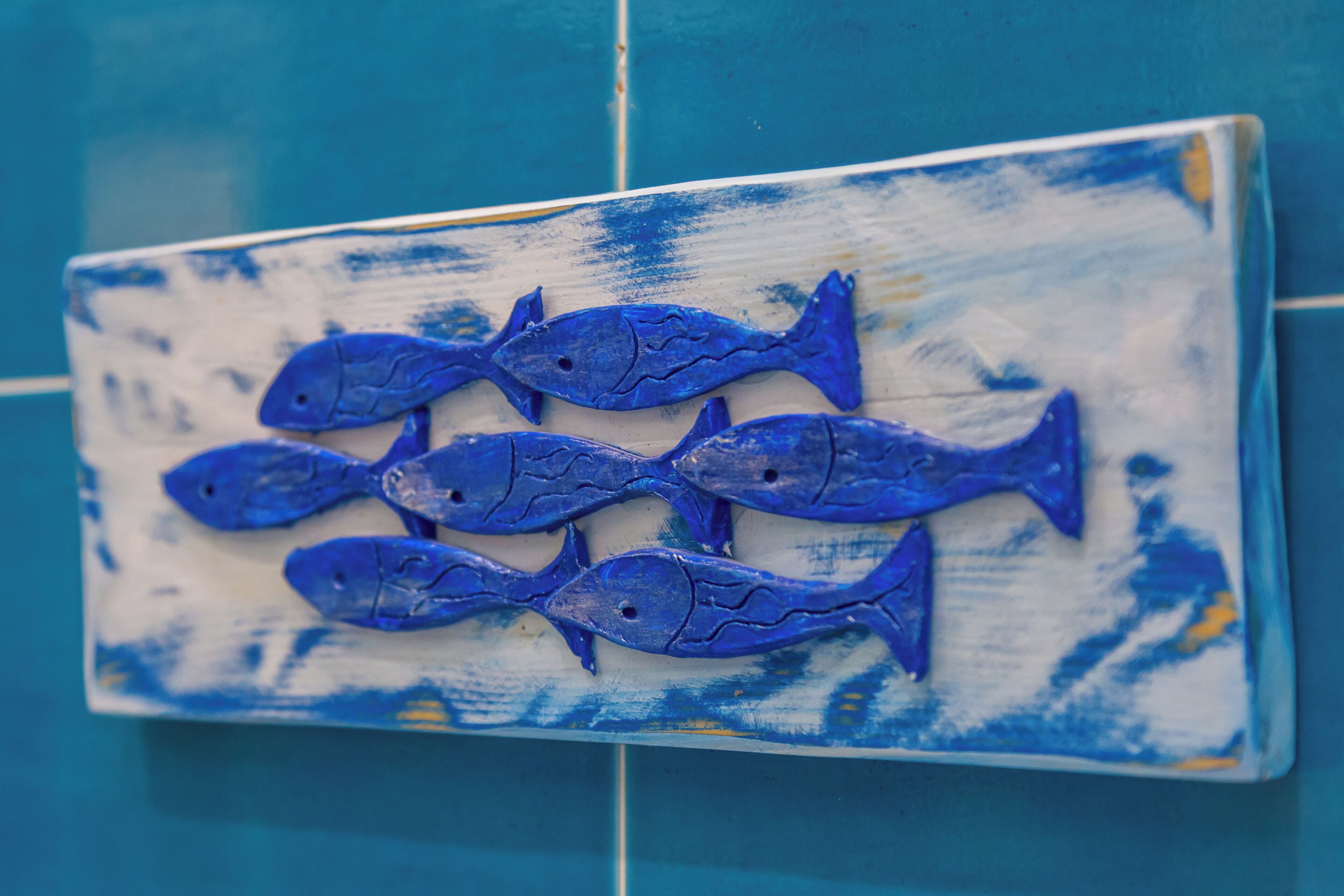 A decorative tile with a blue fish pattern.