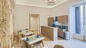 A modern dining area with a chandelier, wooden accents, and a view to the outside. - Dimora Carella (Palermo)