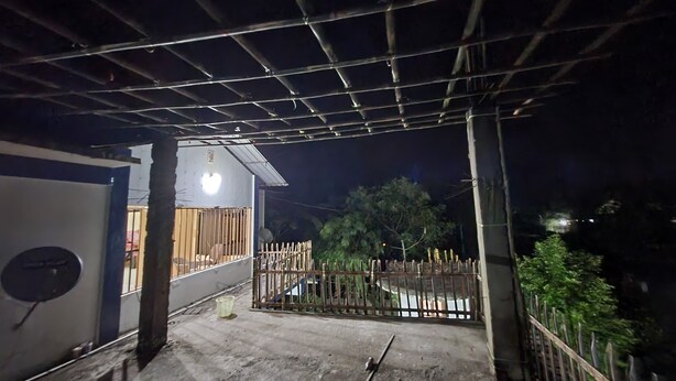 A building with a metal roof structure, a gated entrance, and a satellite dish. - Akash Deep Bhawan By GRB (Bokakhat)