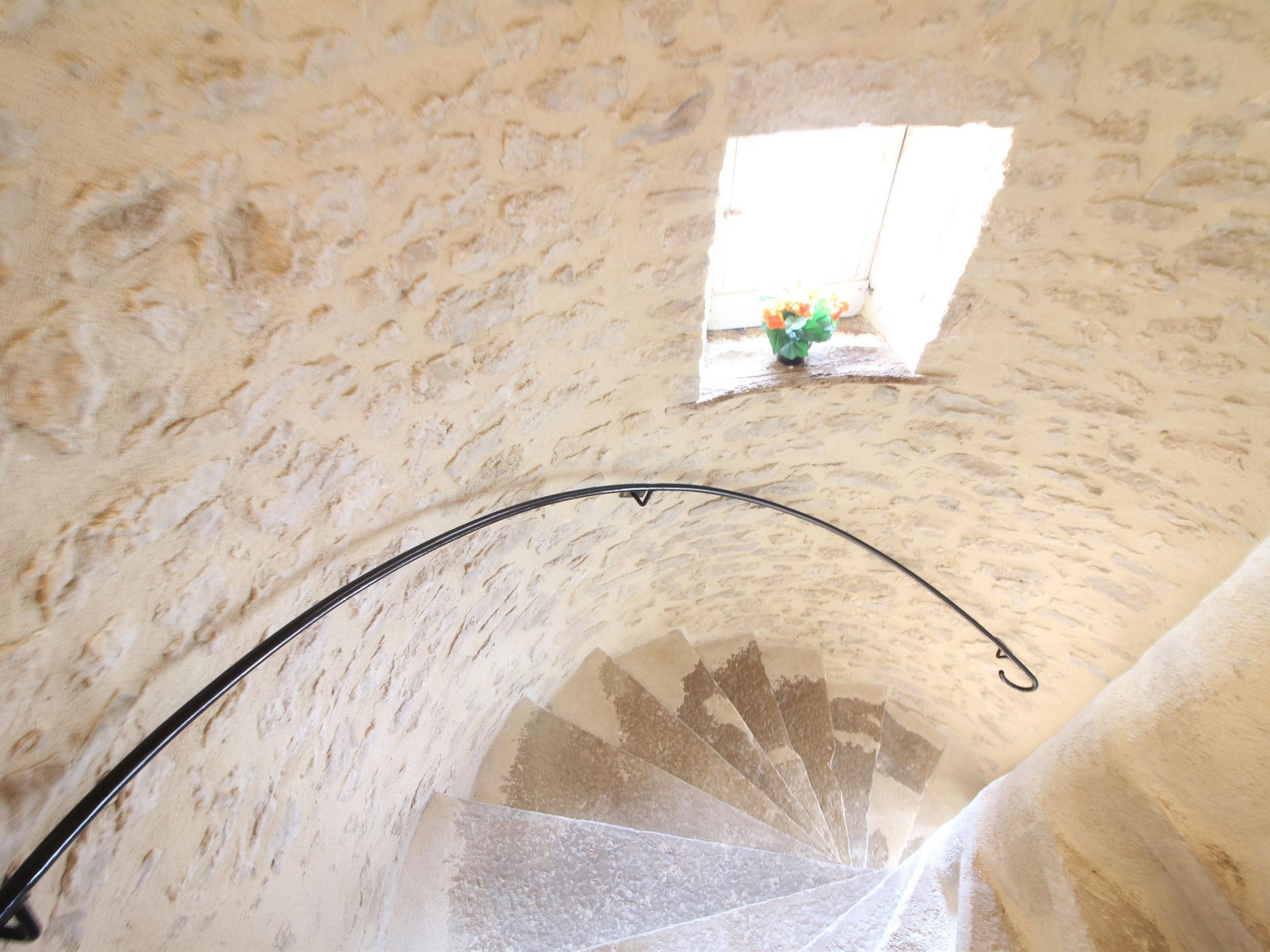 Un intérieur en pierre avec une fenêtre et une structure métallique incurvée.