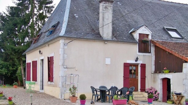 A two-story house with a gravel driveway, outdoor seating, and potted plants. - Countryside Retreat with Fitness Space in La Berthenoux (La Berthenoux)