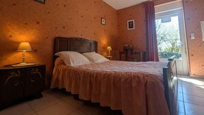 A bedroom with a bed, two bedside tables, a window with curtains, and a door. - Countryside Retreat with Fitness Space in La Berthenoux (La Berthenoux)