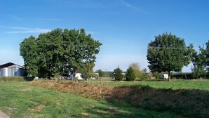 A rural landscape with a barn, trees, and a dirt path. - Countryside Retreat with Fitness Space in La Berthenoux (La Berthenoux)