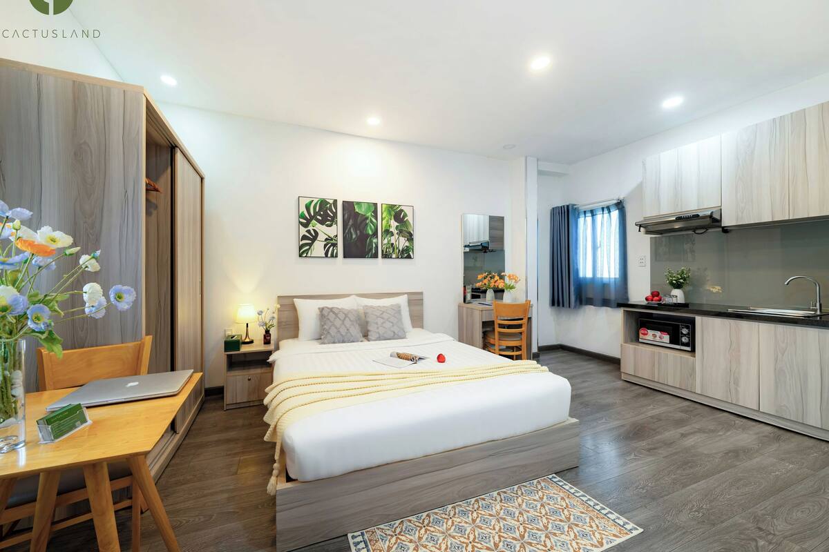 Une chambre d’hôtel moderne équipée d’un lit, d’un bureau et d’une kitchenette.