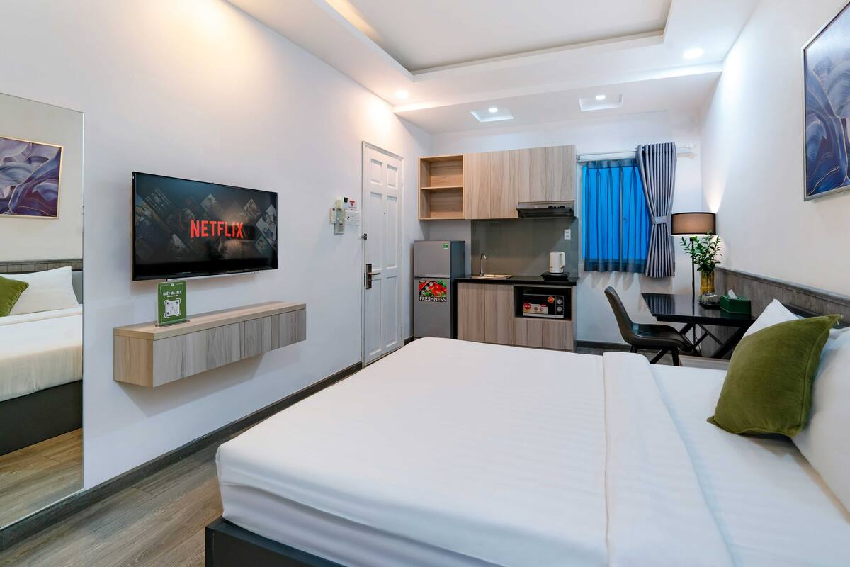 Une chambre d’hôtel comprenant un lit, une télévision, une petite kitchenette et un coin repas.