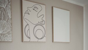 Une chambre à coucher avec un lit, des oreillers et deux œuvres d’art encadrées accrochées au mur.