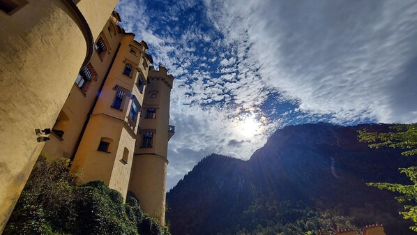 A castle with multiple towers and a mountainous backdrop.