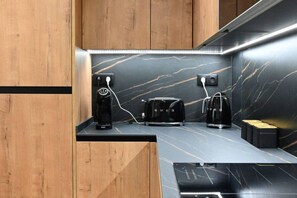 Une cuisine moderne dotée d’un plan de travail en marbre, d’une machine à café, d’un grille-pain et d’une bouilloire.