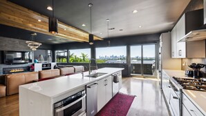 A modern kitchen with a large island, stainless steel appliances, and a city view.