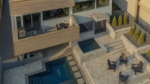 A modern house with a swimming pool, outdoor seating, and a landscaped garden.