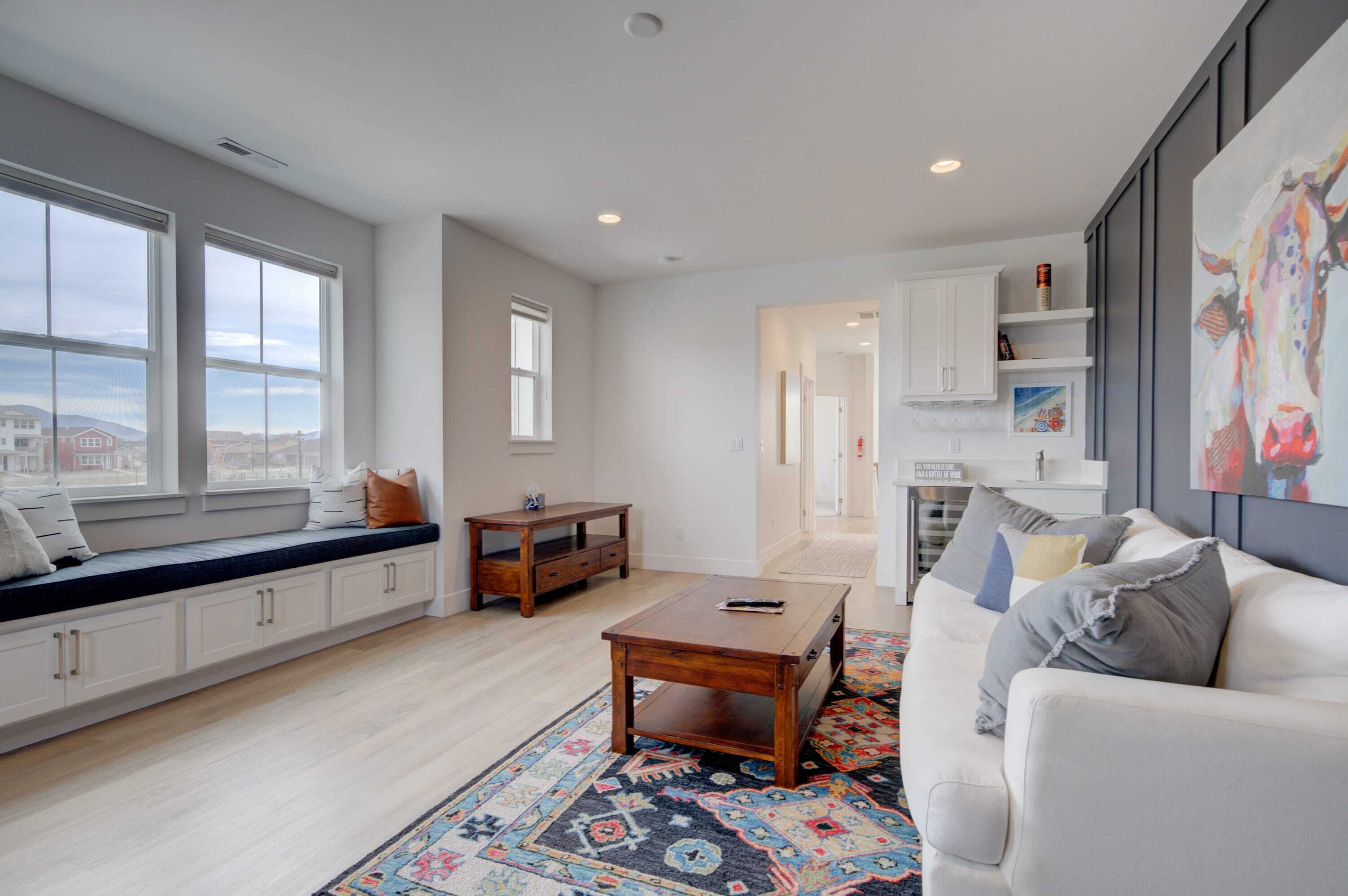 A modern living room with a sofa, coffee table, and built-in seating with storage.