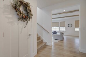A modern interior with a staircase leading to a living area, a wooden floor, and a wall clock. - Spacious Montana home near Big Sky and BZN airport (Belgrade)
