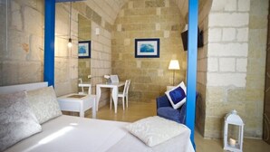 Une chambre à coucher avec un lit, un bureau et une chaise, le tout dans des tons de blanc.