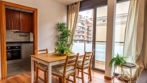 Eine moderne Wohnung mit Essbereich, Küche und Balkon.