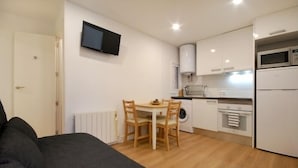 A compact living space with a kitchenette, a dining area, and a bed. - Functional apartment near Barcelona (L'Hospitalet de Llobregat)