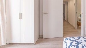 A hallway with a white wardrobe, a partially open door, and a patterned ottoman. - Beautiful apartment in down town Barcelona (Barcelona)