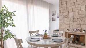 A dining area with a round table, white chairs, and a potted plant. - Beautiful apartment in down town Barcelona (Barcelona)
