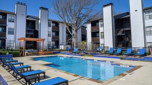 A swimming pool with lounge chairs and a gazebo, surrounded by apartment buildings. - The Landry 157 | Spacious and Cozy 1 Bedroom 1bth (Arlington)