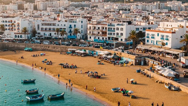 A coastal town with a sandy beach, several boats, and buildings with balconies. - Aphrodite Apartment (Tangier)