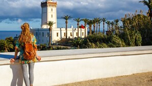 A coastal view with a lighthouse and palm trees. - Aphrodite Apartment (Tangier)
