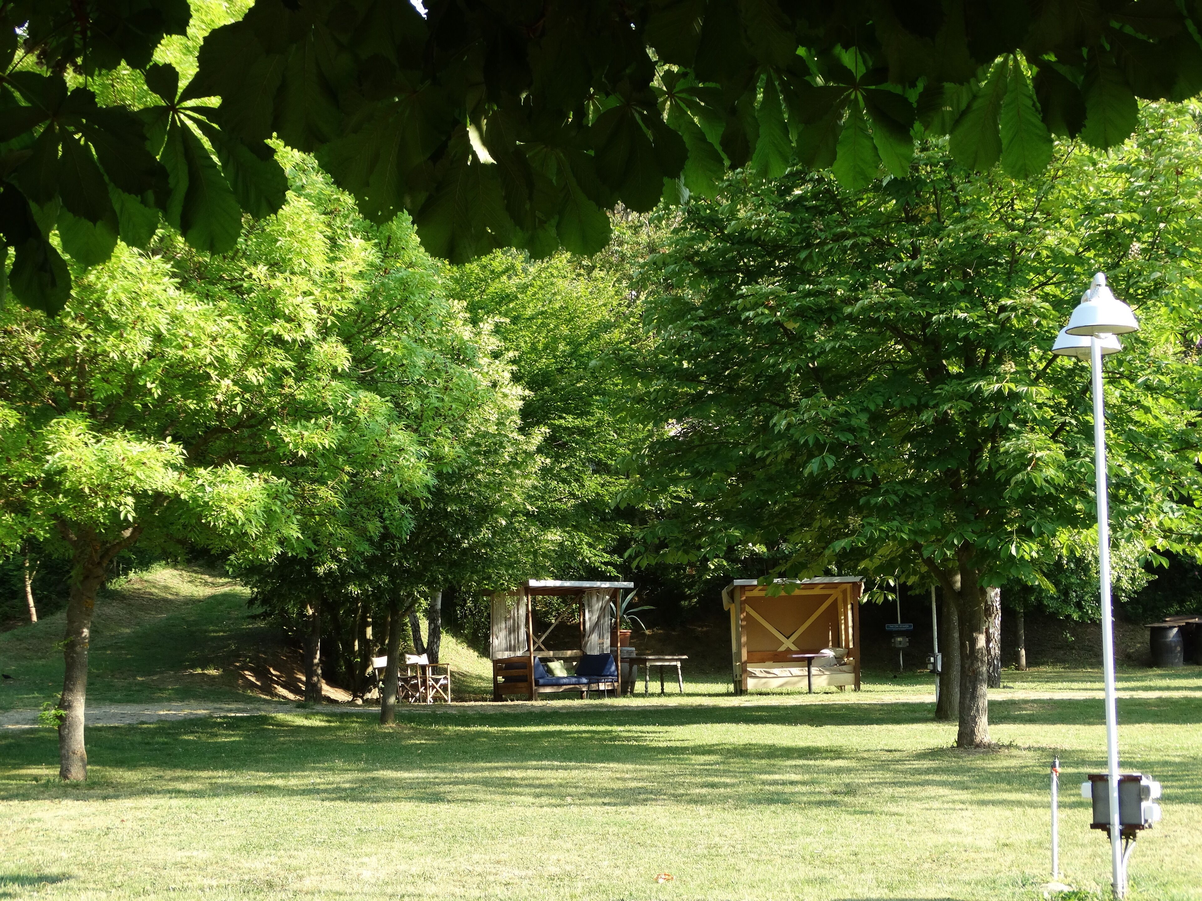 Ein Campingplatz mit Zelten, Tischen und einer Straßenlaterne.