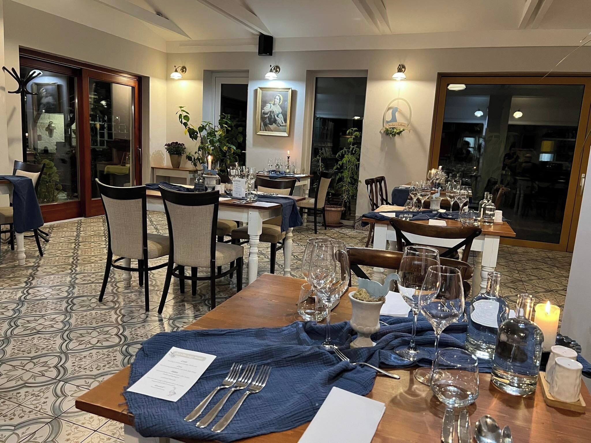 Un espace repas avec des tables dressées pour le repas, des chaises et un sol à motifs.