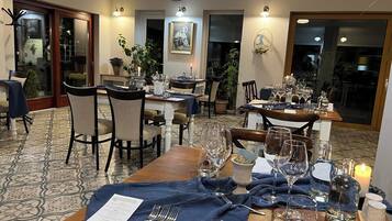 Un espace repas avec des tables dressées pour le repas, des chaises et un sol à motifs.