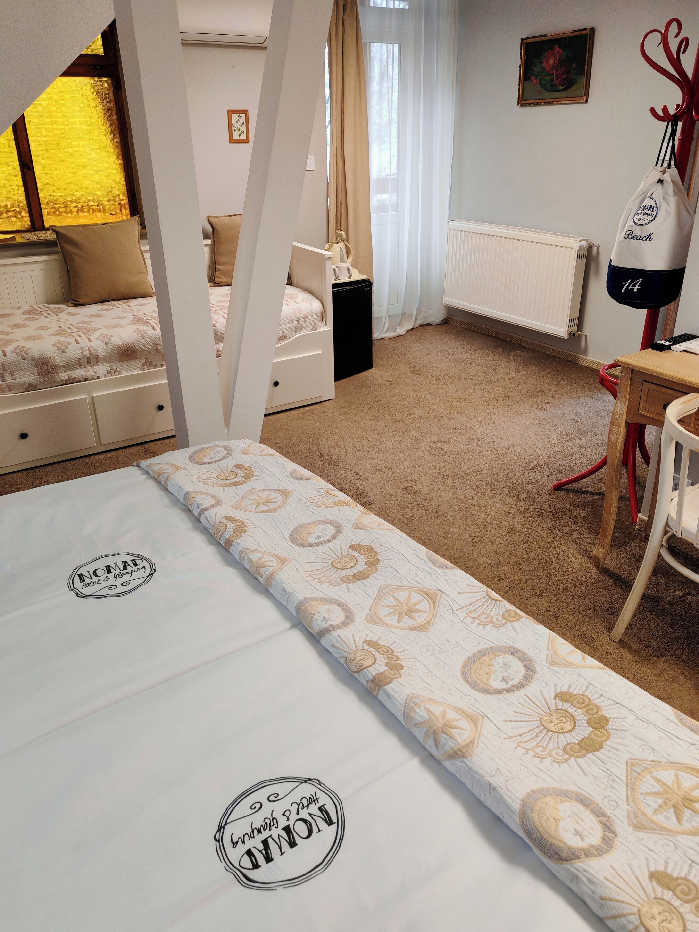 Un dormitorio con una cama litera, un escritorio, una silla, un radiador y una ventana con cortinas.