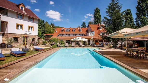 Un complejo turístico con piscina, mobiliario exterior y restaurante.