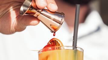 Une personne verse une boisson dans un verre muni d’une paille.