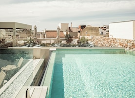 Una piscina al aire libre, sillones reclinables de piscina
