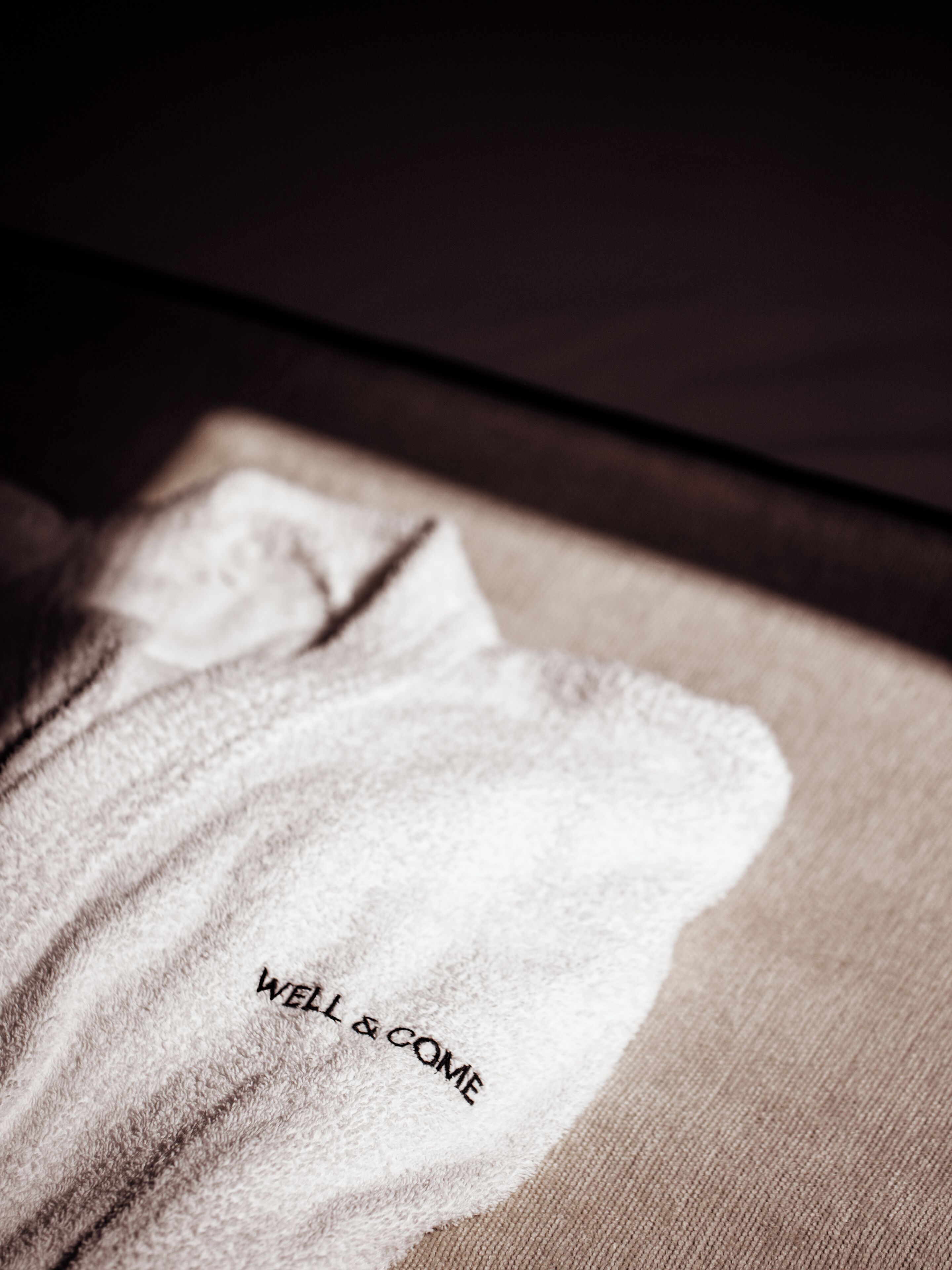 Una toalla con el texto 'WELL & COME'.