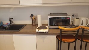 Eine Küche mit Spüle, Toaster, Mikrowelle, Wasserkocher und Waage.