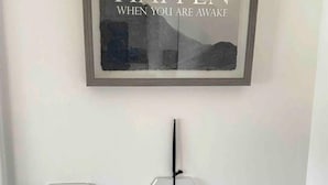 Ein gerahmtes Bild mit dem Text „WHEN YOU ARE AWAKE“ und ein darunter befindliches Schild mit der Aufschrift „WI-FI“.