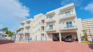 A multi-story residential building with balconies, a gated entrance, and a parking area. - Coral Cove (South Padre Island)