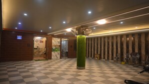 A lobby with a checkered floor, a green pillar, and a row of chairs. - Hotel Prince (Gorakhpur)