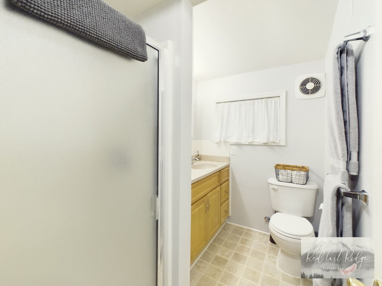 Une salle de bain équipée de toilettes, d’un lavabo et d’un porte-serviettes.