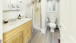 A modern bathroom with a wooden vanity, a glass shower enclosure, and a toilet. - NEW OSU Reser Stadium Glamour- KING BEDS (Corvallis)